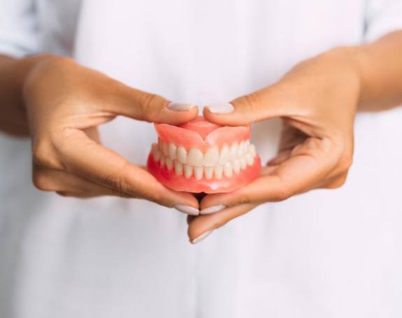 Lady presents viewer with dentures