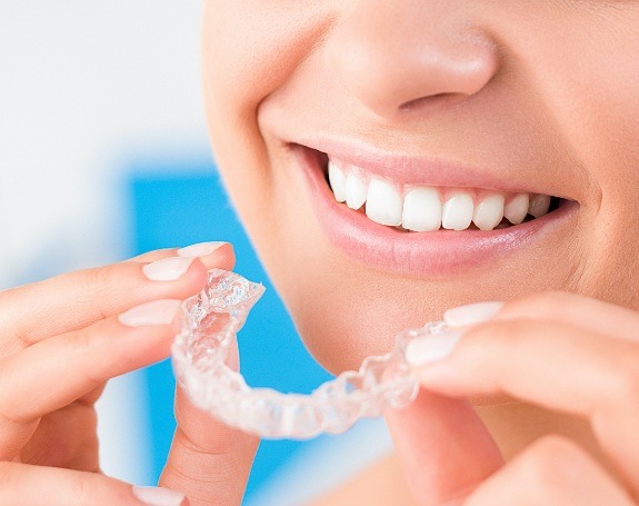 Closeup of patient placing an Invisalign tray