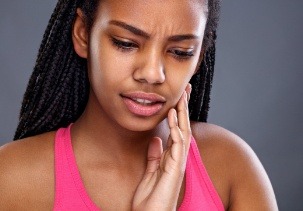 Woman with toothache holding cheek
