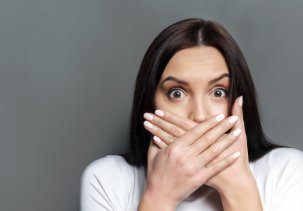 Woman with knocked out tooth covering her mouth