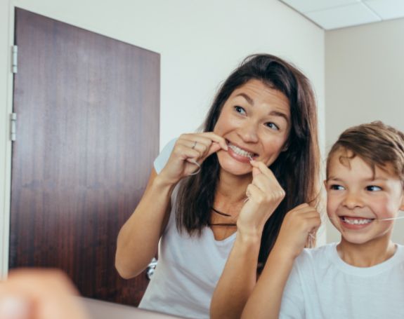 Mother and child flossing to prevent dental emergencies