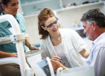 Patient talking to dentist and dental team member