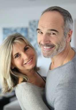 Man and woman with healthy smiles after restorative dentistry