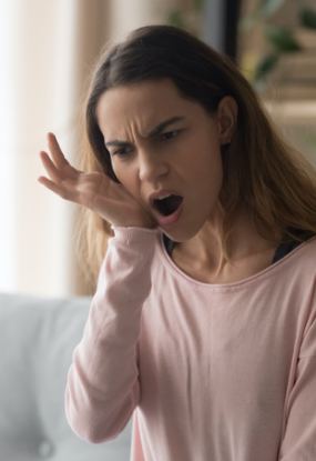 Woman in need of T M J therapy holding jaw in pain