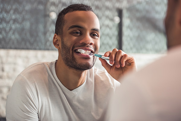 person using toothpaste for veneers to brush teeth