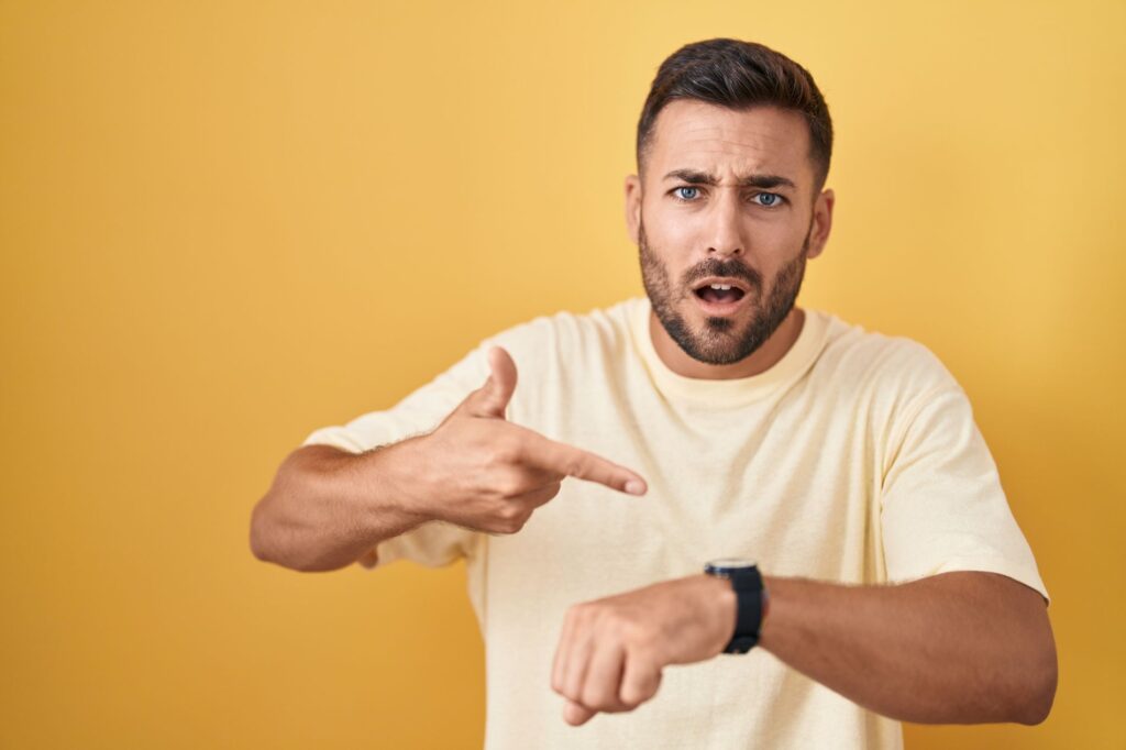 An impatient man pointing to his watch